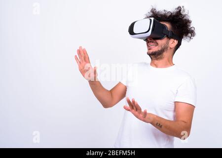 Portrait of bearded Turkish man with curly hair using virtual reality headset Stock Photo