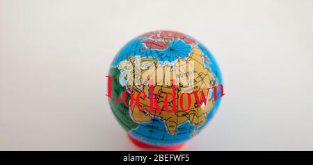 Miniature earth sphere wih the text Lockdown written in red to signify COVID-19 emergency Sweden Stock Photo