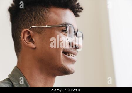 Closeup image of young happy positive smiling african guy in the morning wearing eyeglasses. Stock Photo