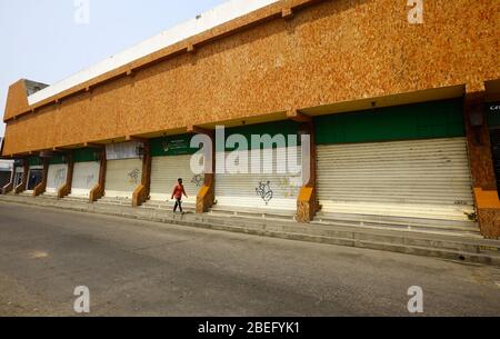 Guacara, Carabobo, Venezuela. 13th Apr, 2020. April 13, 2020. A man walks in front of some closed shops in the streets of the central town of Guacara, Carabobo state. Photo: Juan Carlos Hernandez Credit: Juan Carlos Hernandez/ZUMA Wire/Alamy Live News Stock Photo