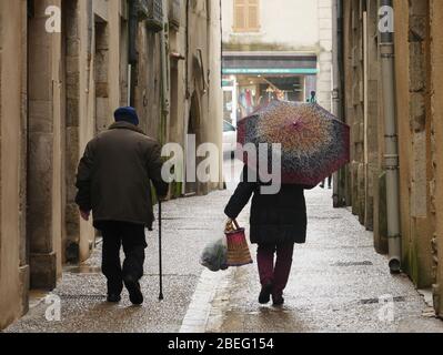old couple walking in the stret on a rainy day Stock Photo