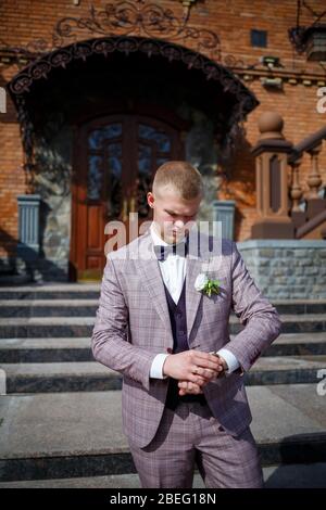 Groom in a beautiful plaid suit and bow-tie Stock Photo