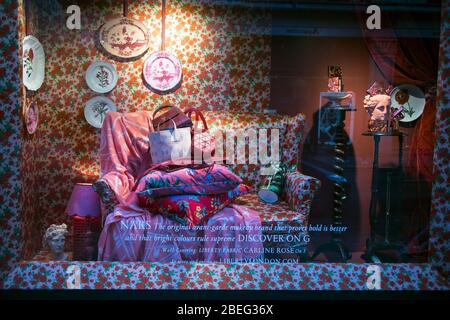 London, UK - 15 February, 2020, A floral sofa with pillows is displayed in a Liberty display case at the Regent street Stock Photo