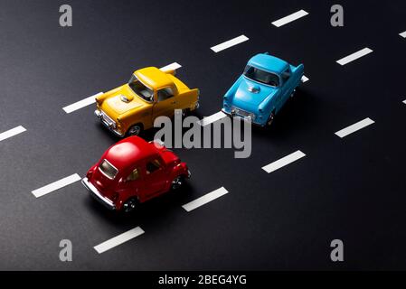 Incorrect overtaking by toy model cars on a road with stripes. Stock Photo