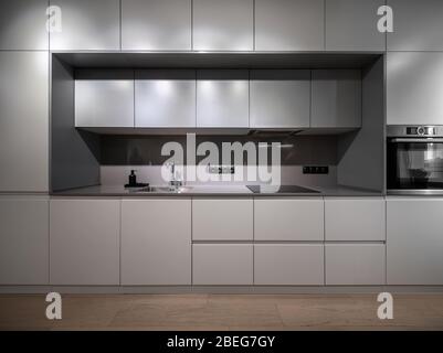 Interior of illuminated modern kitchen with parquet floor Stock Photo
