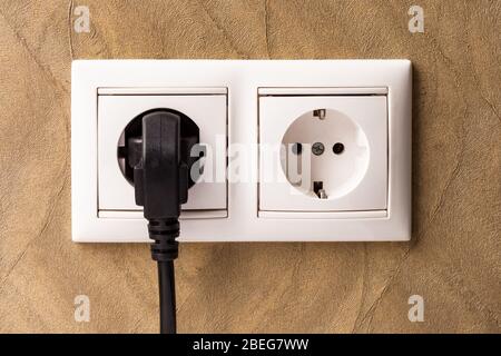 European double white electrical outlet socket, device connected . Stock Photo