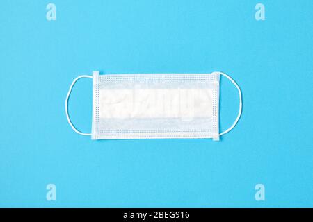 Protective medical mask on a blue background. Top view. Stock Photo