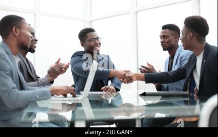 happy business partners shaking hands at meeting in the office. Stock Photo