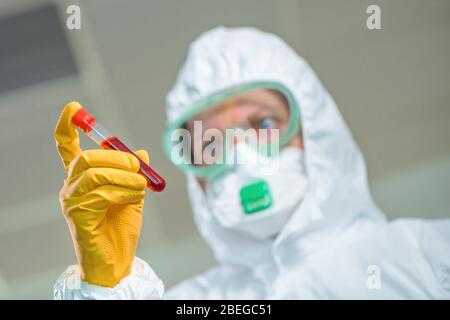 Epidemiologist examining medical sample test tube in virus quarantine, testing the patient's blood during viral infection outbreak