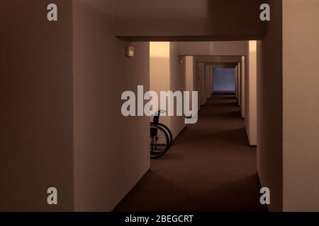 Wheelchair in hospital corridor, diminishing perspective image with no people Stock Photo