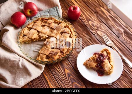 Eating sweet food context. Traditional holidays apple pie, slice and apples. Relishing sweet treats Stock Photo