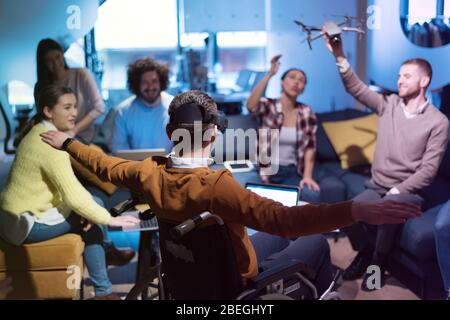 Diverse group of architects working in coworking office using modern technology. Startup people in office working on drone technology. Stock Photo