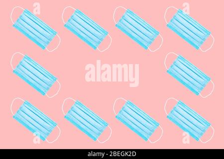 many blue medical face masks isolated on a pink background. copy space. flat lay. concept of protection against viruses, bacteria. background for medi Stock Photo
