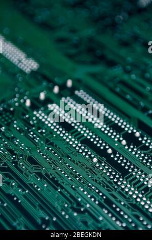 Close-up of shadowy dark green texture of a computer motherboard with selective focus copy space Stock Photo