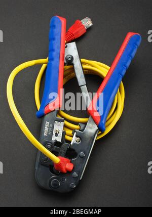 Internet cable crimping tool with LAN cable. Crimping process Stock Photo