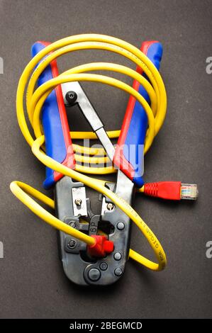 Internet cable crimping tool with LAN cable. Crimping process Stock Photo