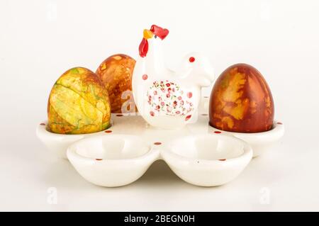 Egg stand made from white porcelain with three Easter eggs isolated on the black background Stock Photo