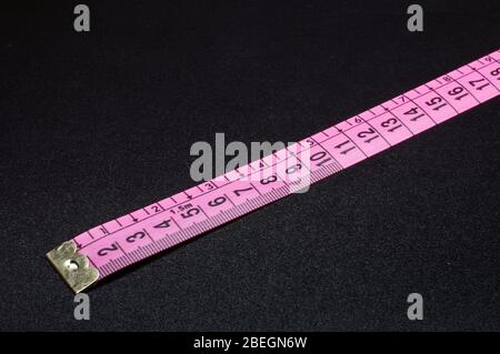 Pink measurement tape close up isolated on the black background Stock Photo