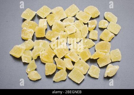 Dried pineapples cubes with sugar isolated on the gray background Stock Photo