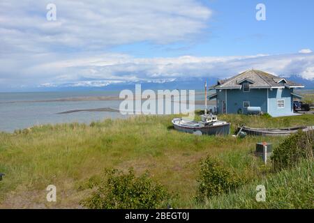 A house and fishing boat on the shoreline of Homer Spit, Alaska, USA Stock Photo