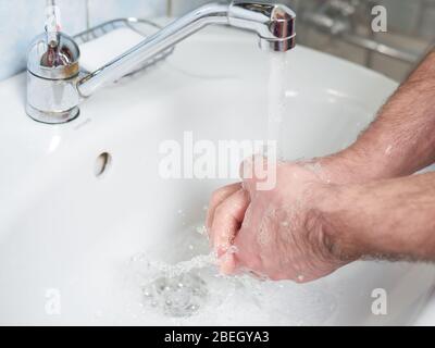 Hygiene concept. Washing hands with soap under the faucet with water. Coronavirus protection.