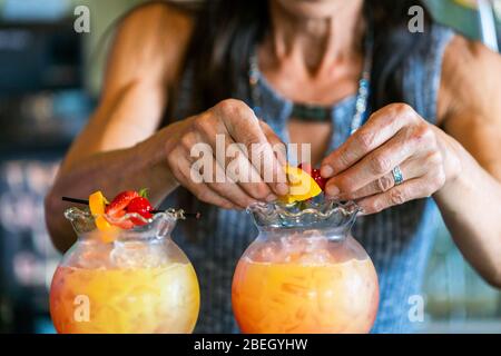 Close up of middle aged woman's hands making drinks with fruit Stock Photo