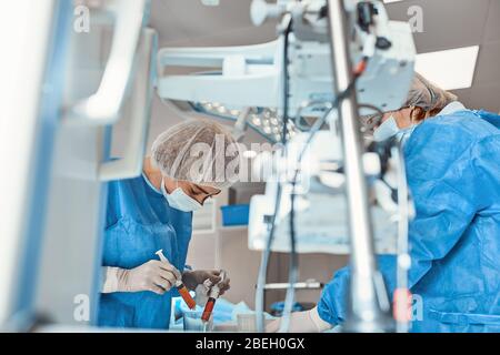 A team of doctors performs an operation. A group of surgeons at work in the operating room, saving the life of the patient from pneumonia. The fight Stock Photo