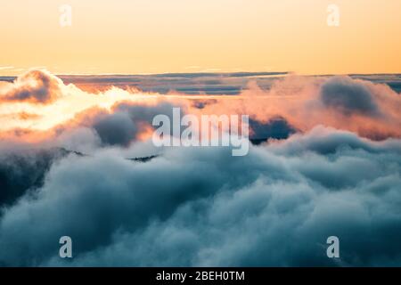 Landscape of sun breaking through clouds and fog at sunrise Stock Photo