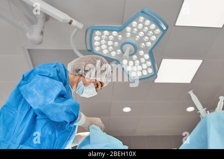 A team of doctors performs an operation. A group of surgeons at work in the operating room, saving the life of the patient from pneumonia. The fight Stock Photo