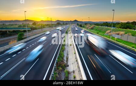 Busy highway at sunset, vehicles coming and going, city stress Stock Photo