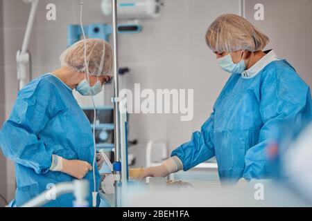 A team of doctors performs an operation. A group of surgeons at work in the operating room, saving the life of the patient from pneumonia. The fight Stock Photo