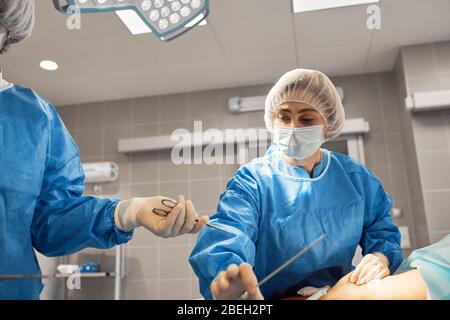 Photographs of doctors in protective masks and lab coats work intensively in intensive care. Resuscitation department, life saving, pneumonia, Covid Stock Photo