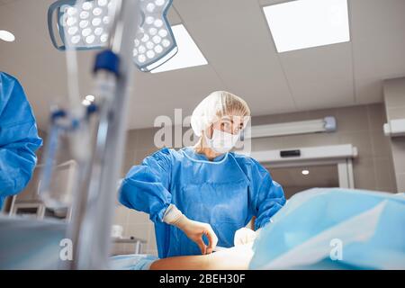 A team of doctors performs an operation. A group of surgeons at work in the operating room, saving the life of the patient from pneumonia. The fight Stock Photo