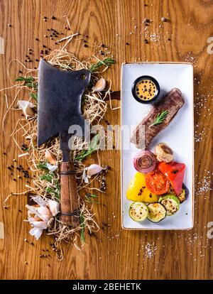 Beef Steak with a choper. Well done Steak with grilled vegetables. Top view, copy space. Stock Photo