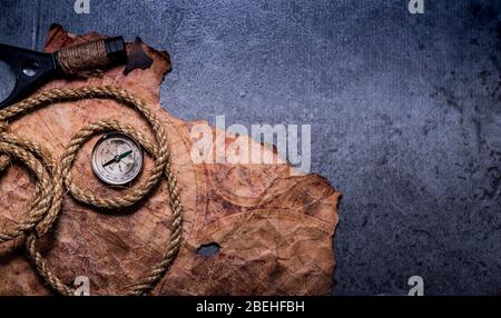 Columbus Day. Pirates and treasure with vintage worldmap and discovery of old equipment. Copy space on dark background. Stock Photo