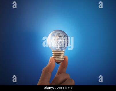 Saving energy and earth day concept. Hand holding glowing earth light bulb. Element of this image are furnished by NASA Stock Photo
