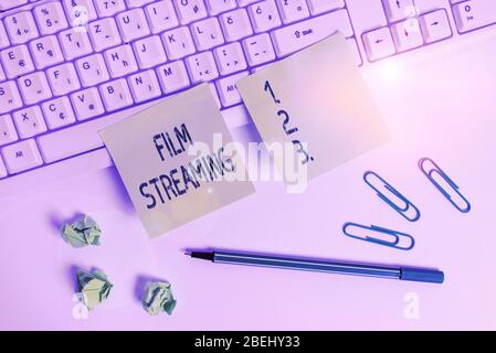 Handwriting text writing Film Streaming. Conceptual photo act of watching sound or video directly from the internet Square green note paper with penci Stock Photo