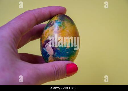 Human hand holding single colorful egg, body part, fingers, one multicolored egg, Easter tradition, celebration concept Stock Photo