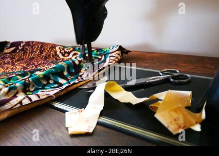 Close-up of vintage sewing machine with fabric, scissors and measuring tape Stock Photo
