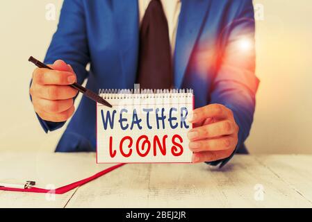 Text sign showing Weather Icons. Business photo text Plotted on a synoptic chart used for weather forecasting Man holds empty paper with copy space in Stock Photo