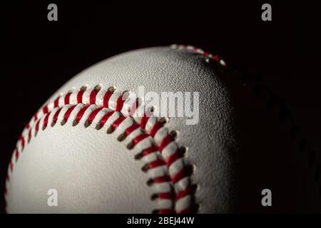A white leather baseball on a black background Stock Photo