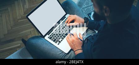 Upper view portrait of a caucasian man working at home with a laptop with free space on the floor Stock Photo