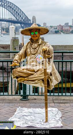 Gold live statue levitating street performance at Sydney Harbour Stock Photo