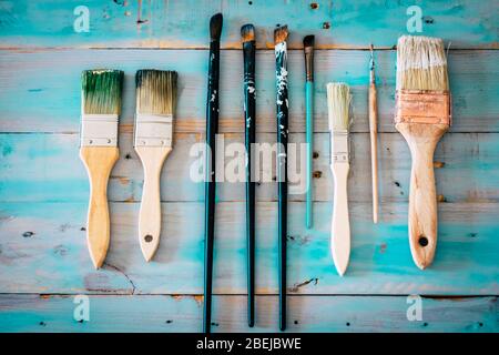 Paint and brushes concept for hobby and indoor home leisure activity concept on a blue hand made wooden table background Stock Photo