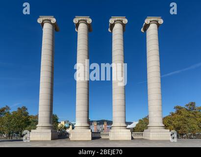 Beautiful Four white columns near the Royal Palace against the backdrop of the city and the extremely blue sky in Barcelona, Spain. Stock Photo