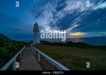 Cape Otway historic lighthouse shadowy and moody on southern point of Australiaunder dramtic sky at sunset in state of Victoria. Stock Photo