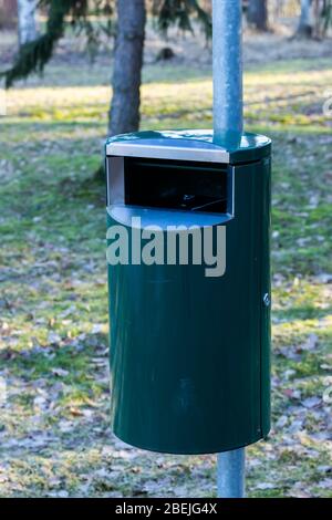 Green metal trash can in a park in Finland Stock Photo