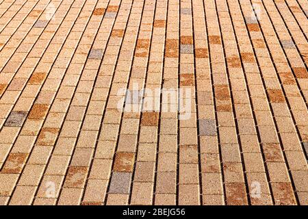Top view on orange paving stone road. Old pavement of granite texture. Street cobblestone sidewalk. Abstract background for design. Stock Photo