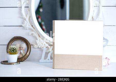 White photo book with leather and wood cover. stylish wedding photo album. Family photoalbum on the white wood table. Stock Photo
