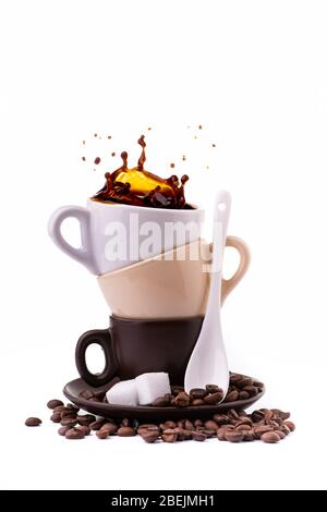 isolated from the white background, a saucer with three different colored coffee cups from which a splash of black coffee is generated. Stock Photo